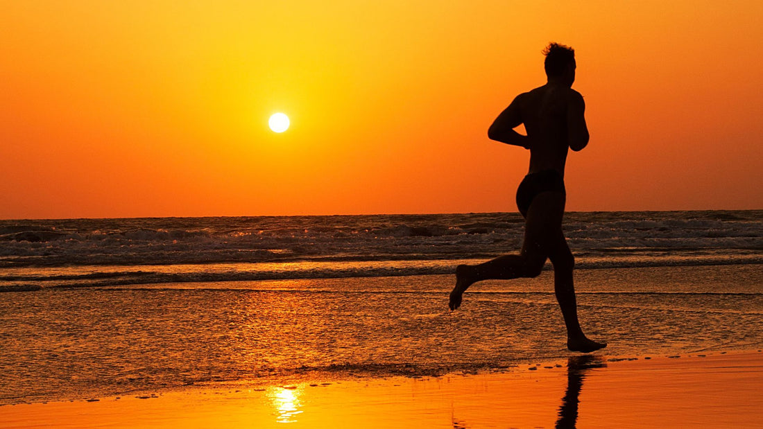 homme qui court sur la plage au coucher du soleil